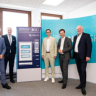 5 Männer stehen an einem Fahrkartenautomaten aus Pappe und haben den Tarifentwicklungsplan beschlossen