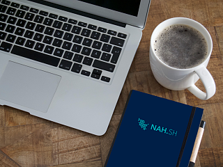 Laptop mit Notizbuch und Kaffee